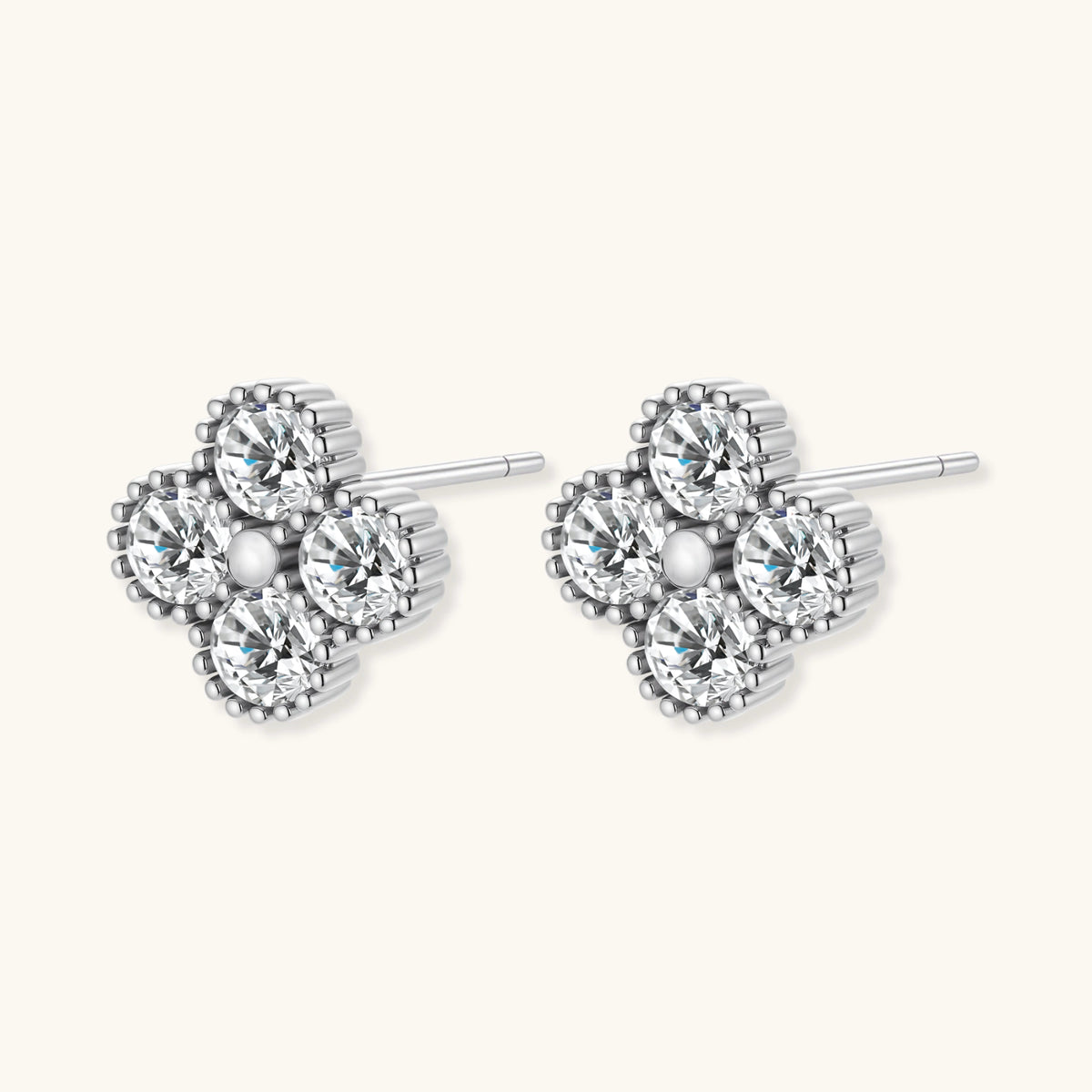 Dainty sterling silver quatrefoil stud earrings with four brilliant moissanite stones and center accent on white background.