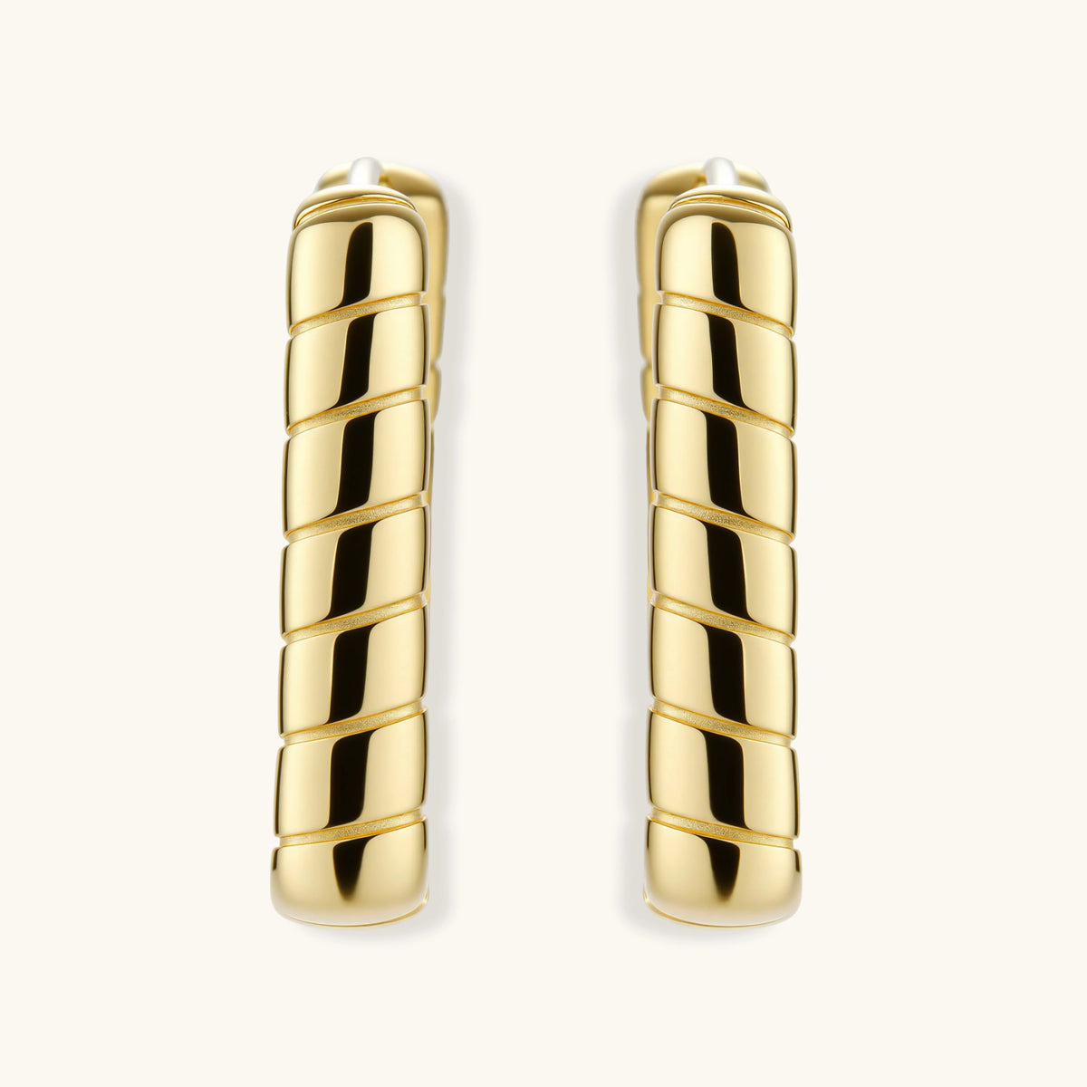 Chunky segmented gold-plated huggie hoop earrings with bamboo-inspired geometric design on white background.