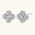 Dainty sterling silver quatrefoil stud earrings with four brilliant moissanite stones and center accent on white background.