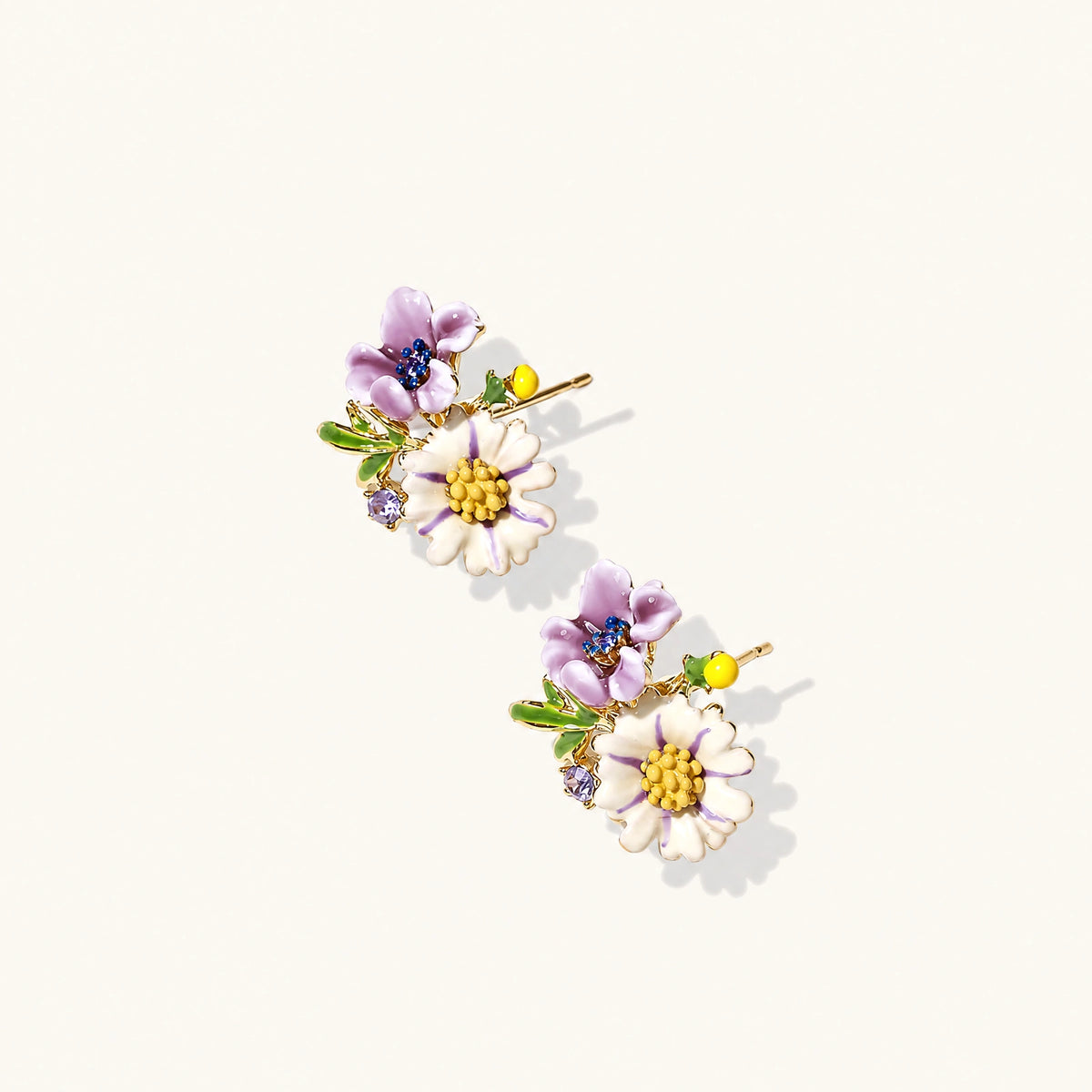 Cluster-style stud earrings with purple pansies, white daisies, yellow centers, and green leaves in glossy enamel finish