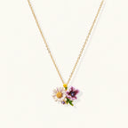Gold-plated necklace with pink and purple enamel flower pendant featuring crystal accents on cream background