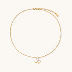 Gold-plated butterfly pendant with iridescent mother of pearl inlay on delicate chain against cream background.