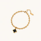 18K gold-plated oval bead bracelet with a four-leaf clover charm in mother-of-pearl or black enamel, adjustable lobster clasp, on white background.