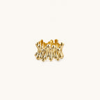 Gold-plated brass ring with sculptural petal-like elements in a wide band design on beige background