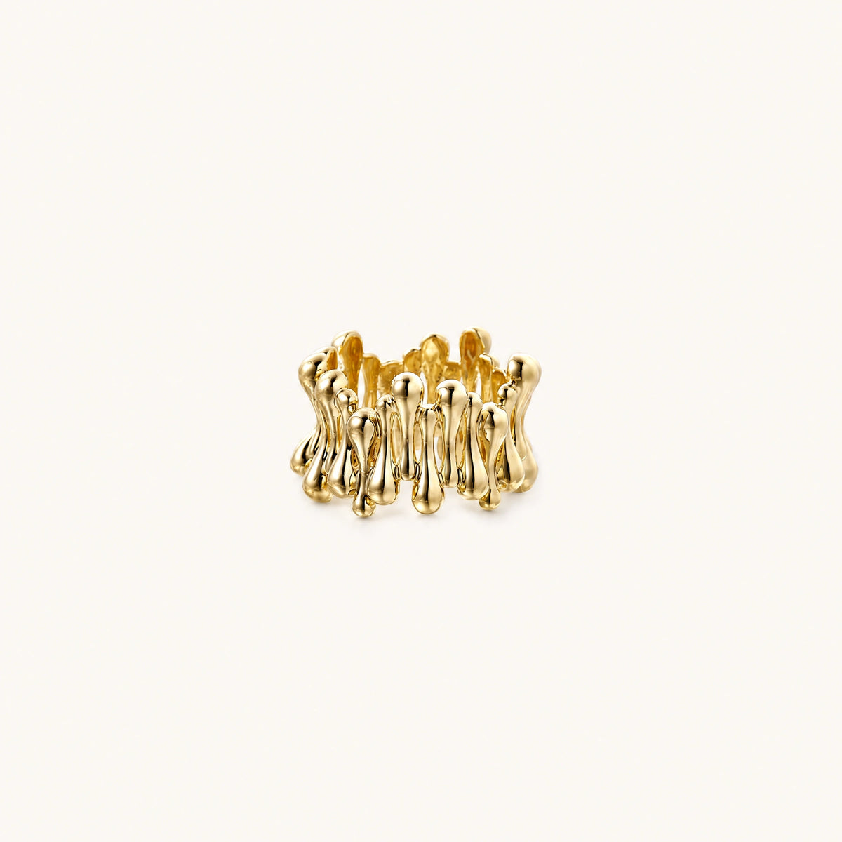 Gold-plated brass ring with sculptural petal-like elements in a wide band design on beige background