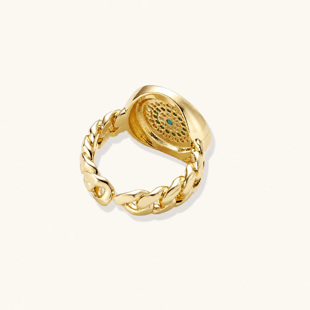 Gold chain ring with Greek key border and turquoise evil eye center on white background