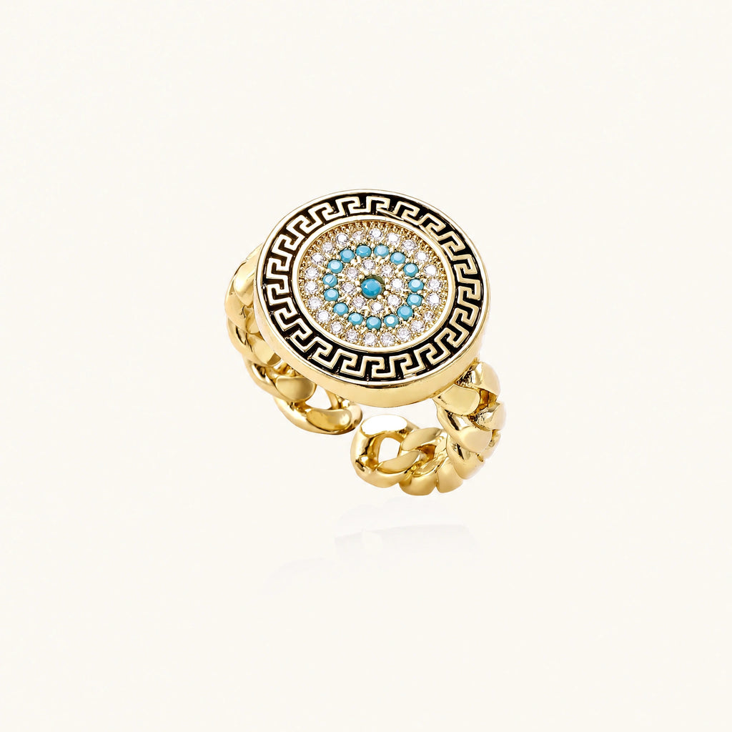 Gold chain ring with Greek key border and turquoise evil eye center on white background